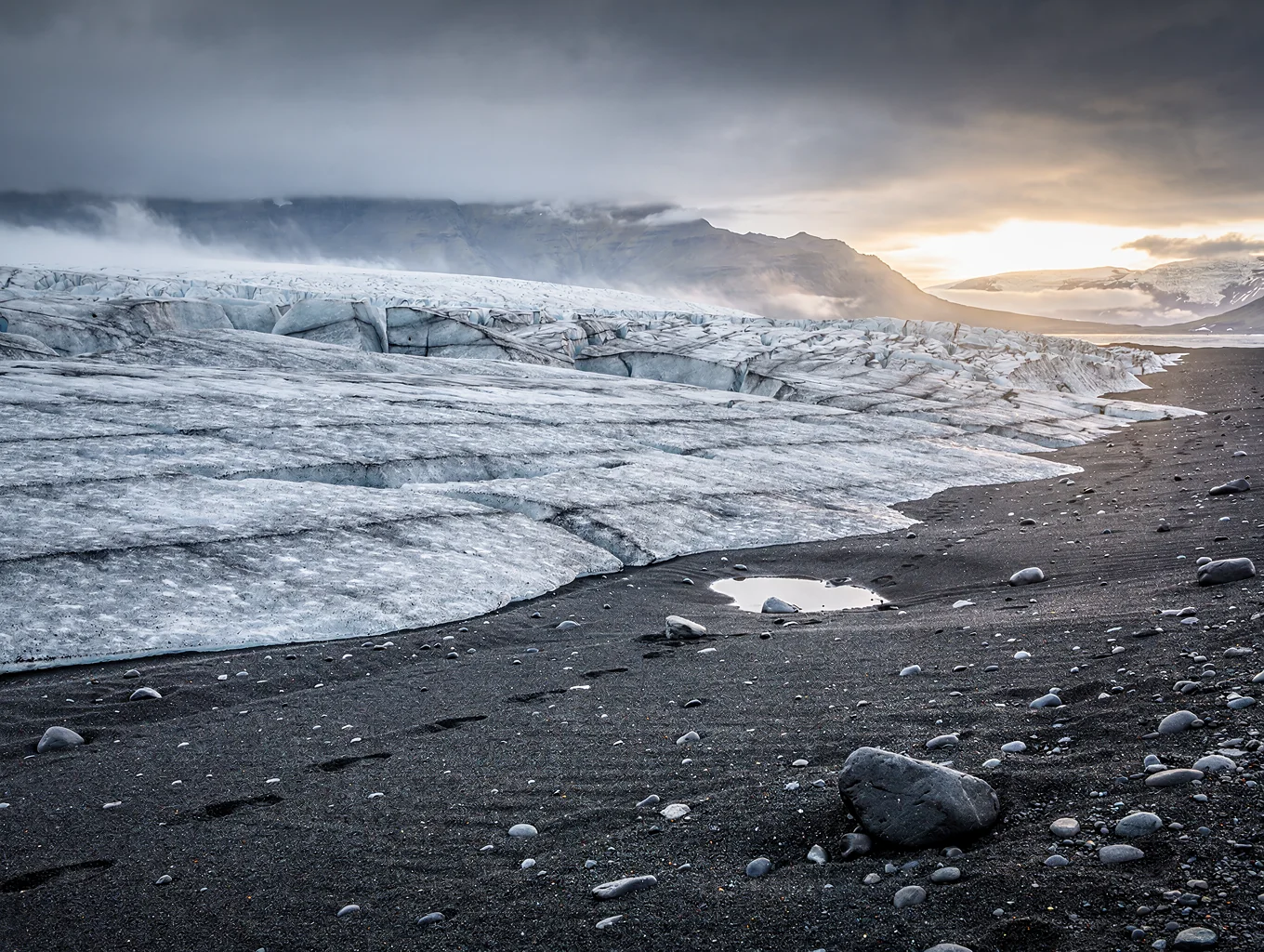 Blue glacial ice on black volcanic sand beach